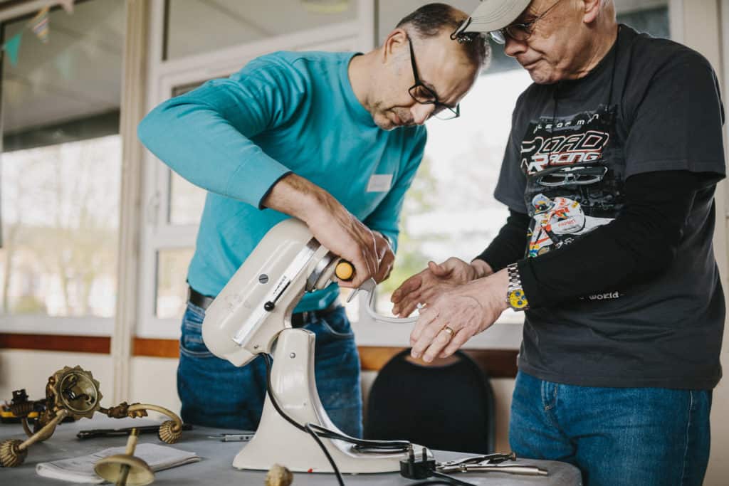 Men repairing a broken food mixer